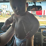 Jameson is registered to the contest to win money with this photo: arm, baby, body, car_interior, child, dashboard, daylight, diaper, face, hand, hands, infant, outdoor, person, rearview_mirror, reflection, skin, steering_wheel, vehicle, window