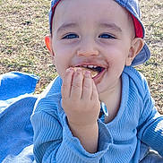 Tom participe au concours pour gagner de l'argent avec cette photo : baby, blanket, blue_cap, casual_clothing, child, cute, daylight, food, fun, grass, happy, nature, outdoor, playful, portrait, sitting, smiling, snack, toddler, young_child