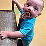 Zander is registered to the contest to win money with this photo: baby, child, pacifier, blue_clothing, chair, floor, indoor, cabinet, curious, hand, footwear, young_child, standing, head, face, expression, furniture, toy, room, person