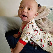 Zander is registered to the contest to win money with this photo: baby, infant, smiling, pajamas, mickey_mouse, bed, blanket, indoors, cute, child, face, happy, person, apparel, sleepwear, soft, comfort, young, cartoon, holiday