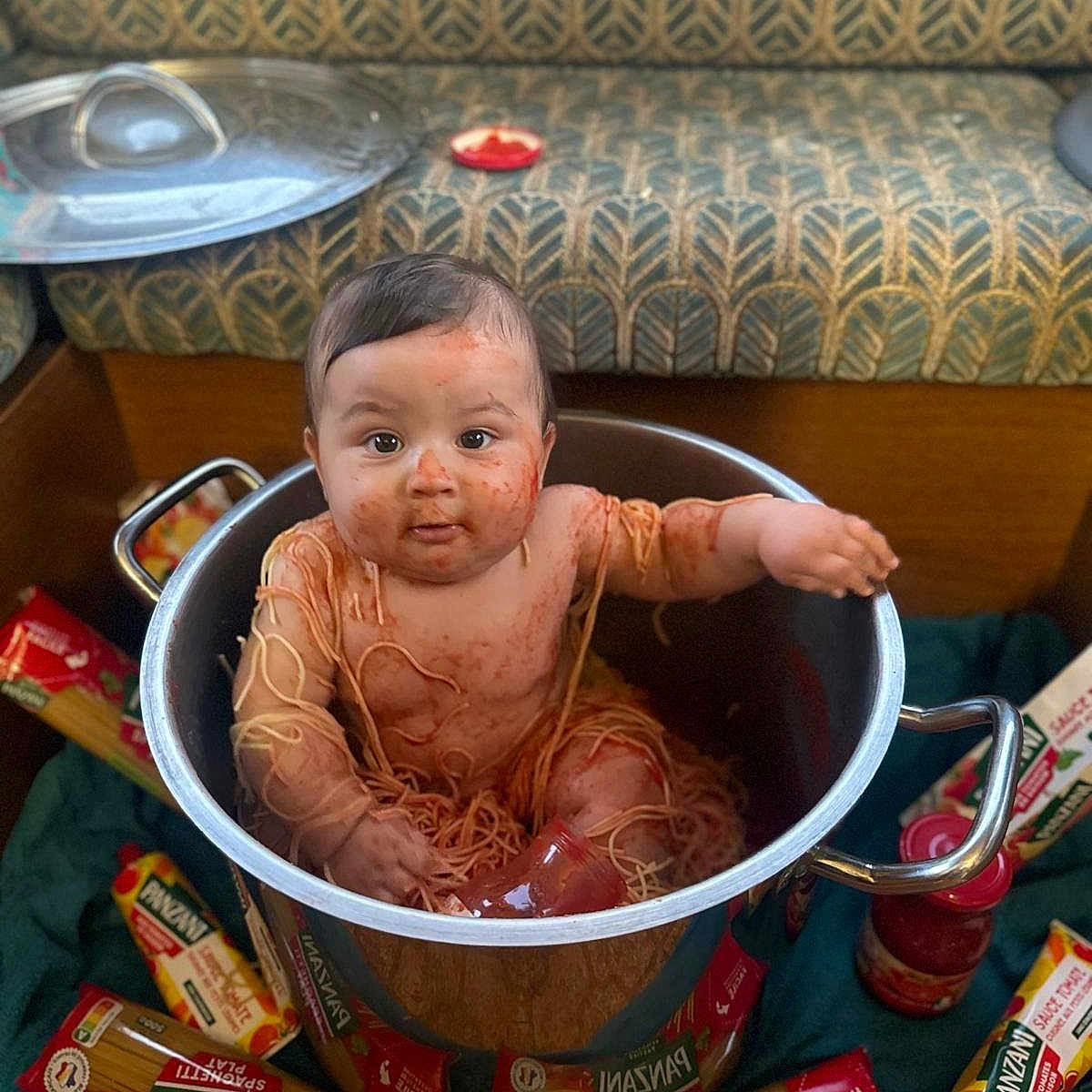 Keyvan a rejoint le concours — aidez-le/la à gagner de superbes lots ! baby, child, cooking_pot, couch, curious, cute, food, funny, indoors, jar, kitchen, mess, messy, packaging, pasta, patterned_fabric, pot, sitting, spaghetti, tomato_sauce