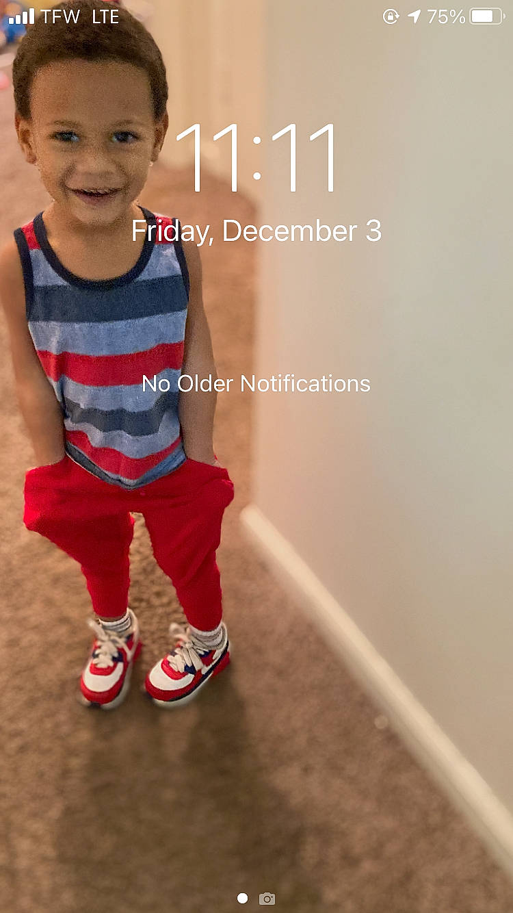 Jaquavon is registered to the contest to win money with this photo: baby_toddler_clothing, electric_blue, flooring, font, fun, gesture, happy, head, human_leg, jersey, joy, knee, logo, person, photo_caption, sitting, sleeve, smile, sock, sportswear