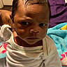Jairus Wright is registered to the contest to win money with this photo: baby, bedroom, blanket, child, colorful_blanket, cute, face, furniture, head, human, indoor, infant, mitten, person, portrait, serious_expression, sitting, towels, white_clothing, young_child