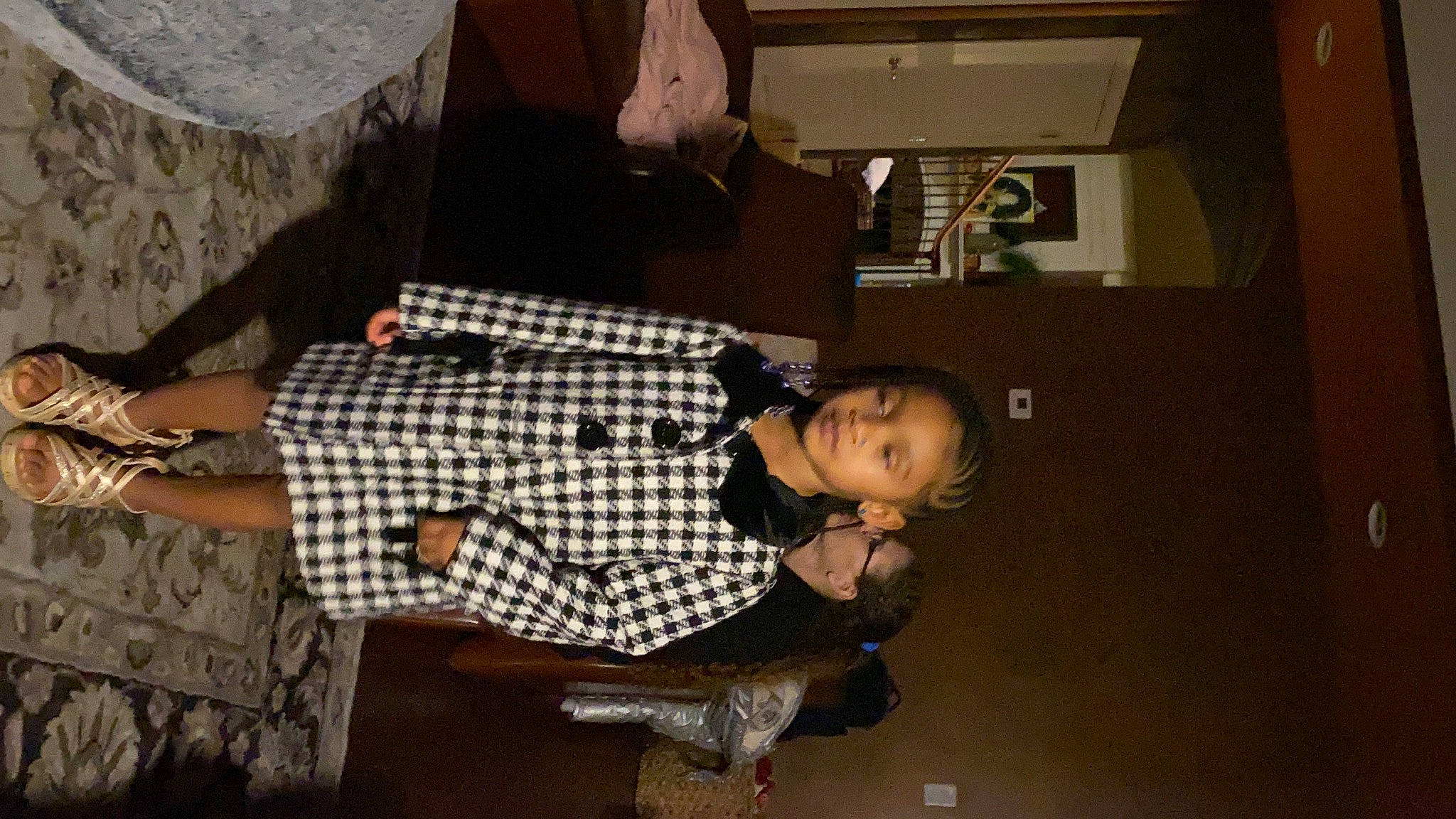 Kaylani is registered to the contest to win money with this photo: fashion_design, flooring, fun, pattern, person, plaid, room, sitting, street_fashion, tartan, thigh, toddler, tree, wood