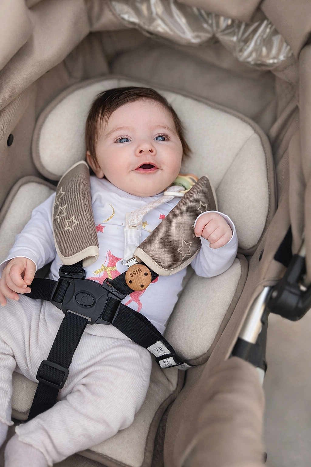 Dina a rejoint le concours — aidez-le/la à gagner de superbes lots ! baby, infant, stroller, car_seat, harness, buckle, onesie, smile, blue_eyes, soft_padding, blanket, wooden_clip, pacifier, cute, chubby_cheeks, portrait, candid, parenting, cozy, fabric