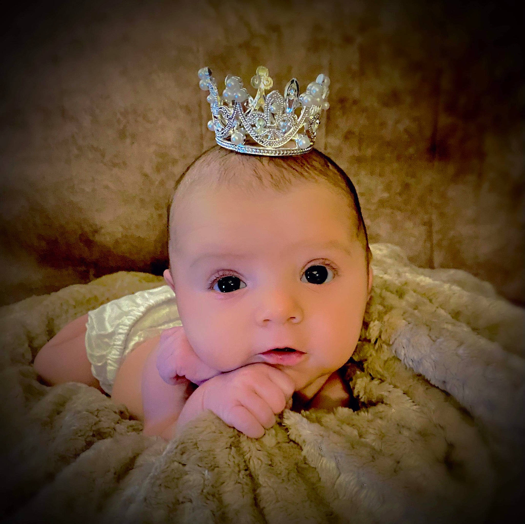 Everly Mae is registered to the contest to win money with this photo: baby, baby_toddler_clothing, bridal_accessory, ear, embellishment, eyebrow, eyelash, finger, flash_photography, hair, hair_accessory, hand, happy, head, headband, headgear, headpiece, jewellery, person, tiara