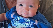 Nora joined the competition — help win amazing prizes! baby, child, infant, portrait, close_up, blue_outfit, bow, cartoon_shirt, sitting, held, adult, face, eyes, looking_at_camera, indoors, family, smiling, photography, clothing, safe
