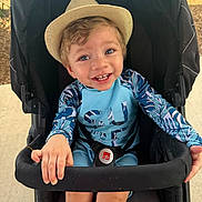 Jaziel Antonio is registered to the contest to win money with this photo: child, toddler, baby, smiling, portrait, stroller, hat, straw_hat, outdoor, sunlight, playful, happy, blue_eyes, colorful_clothing, tropical, travel, seated, harness, fashion, close_up