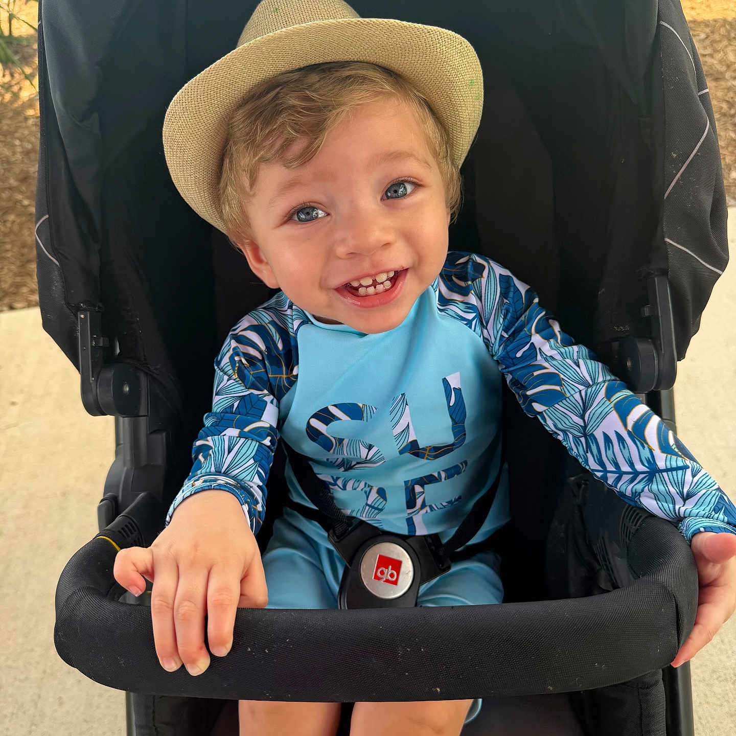 Jaziel Antonio is registered to the contest to win money with this photo: child, toddler, baby, smiling, portrait, stroller, hat, straw_hat, outdoor, sunlight, playful, happy, blue_eyes, colorful_clothing, tropical, travel, seated, harness, fashion, close_up
