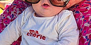 Naomie participe au concours pour gagner de l'argent avec cette photo : baby, sunglasses, adult_hands, reflection, outdoor, floral_dress, colorful_clothing, infant, casual_clothing, cute, portrait, sunny_day, fashion, closeup, child, person, holding, expression, baby_clothes, accessory
