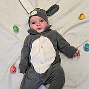 Naomie participe au concours pour gagner de l'argent avec cette photo : baby, costume, bunny, easter_eggs, blanket, cute, infant, lying_down, gray_clothing, white_background, holiday, festive, child, adorable, face, headwear, footed_pajamas, indoors, floor, playful