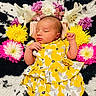 baby, newborn, sleeping, flower_crown, yellow_dress, floral_pattern, blanket, pink_flowers, white_flowers, purple_flowers, yellow_flowers, cute, peaceful, infant, portrait, resting, soft_texture, colorful, adorable, child