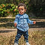 Sohan a rejoint le concours — aidez-le/la à gagner de superbes lots ! toddler, child, curly_hair, blue_shirt, dark_pants, white_shoes, standing, outdoor, grass, sunlight, nature, daylight, young_child, portrait, casual_clothing, person, looking_away, field, curious, exploring