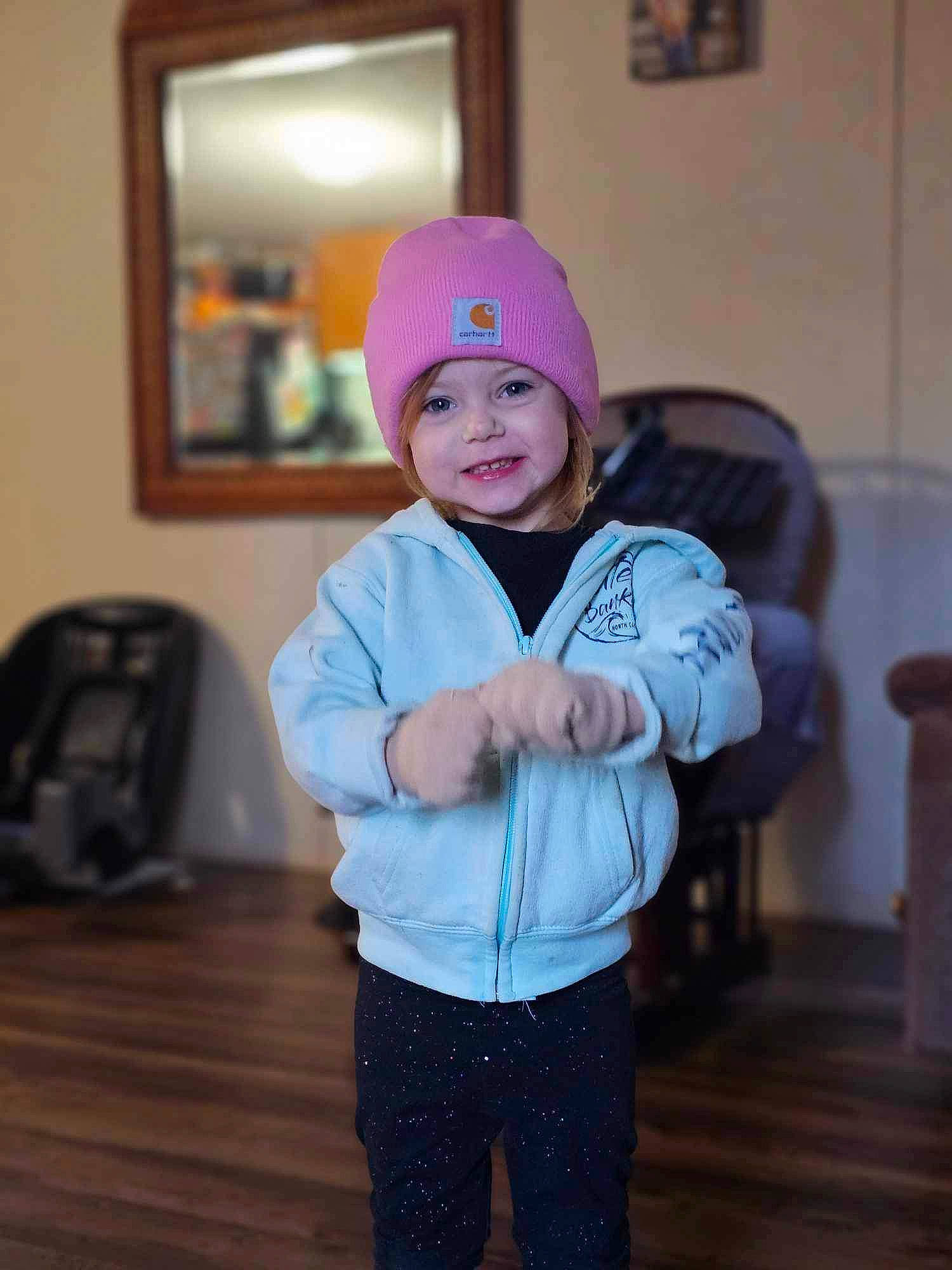 Ariya is registered to the contest to win money with this photo: baby_toddler_clothing, cap, child, electric_blue, event, fashion_accessory, flooring, fun, happy, hardwood, headwear, joy, luggage_and_bags, magenta, mirror, person, personal_protective_equipment, picture_frame, room, sleeve