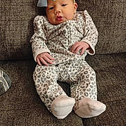 Aneeyah is registered to the contest to win money with this photo: baby, infant, child, pajamas, leopard_print, headband, bow, couch, furniture, cozy, comfortable, hands, face, portrait, indoors, soft, cute, resting, young, person