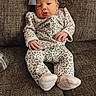 baby, infant, child, pajamas, leopard_print, headband, bow, couch, furniture, cozy, comfortable, hands, face, portrait, indoors, soft, cute, resting, young, person