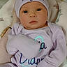 Lycia is registered to the contest to win money with this photo: baby, infant, hat, bow, clothing, purple, blanket, sleepwear, cute, face, newborn, soft, resting, indoors, person, portrait, young, cozy, lying, child