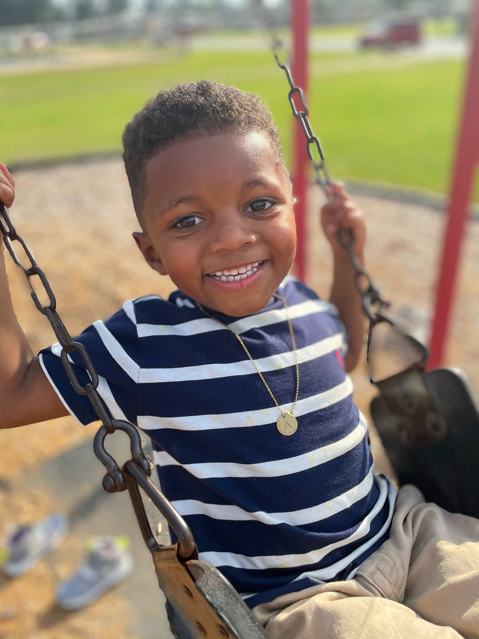 Ashton-amari is registered to the contest to win money with this photo: child, cool, facial_expression, fun, grass, hairstyle, hand, happy, human, joy, leaf, leisure, outdoor_play_equipment, person, playground, product, public_space, recreation, skin, smile