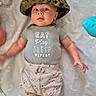 Noah joined the competition — help win amazing prizes! baby, blanket, camouflage, casual, child, clothing, curious, cute, expression, hat, indoor, infant, lying_down, onesie, pattern, person, playmat, smiling, soft_toys, young_child