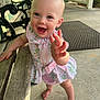 Ellie is registered to the contest to win money with this photo: baby, child, smiling, barefoot, dress, floral_pattern, porch, wooden_bench, concrete_floor, happy, person, outdoor, railing, green_wall, mat, cute, young_child, reaching_hand, standing, sunlight