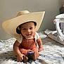 Salux is registered to the contest to win money with this photo: baby, child, hat, cowboy_hat, overalls, brown_shoes, sitting, blanket, indoor, smiling, cute, person, infant, soft_texture, home, apparel, face, headwear, footwear, playful