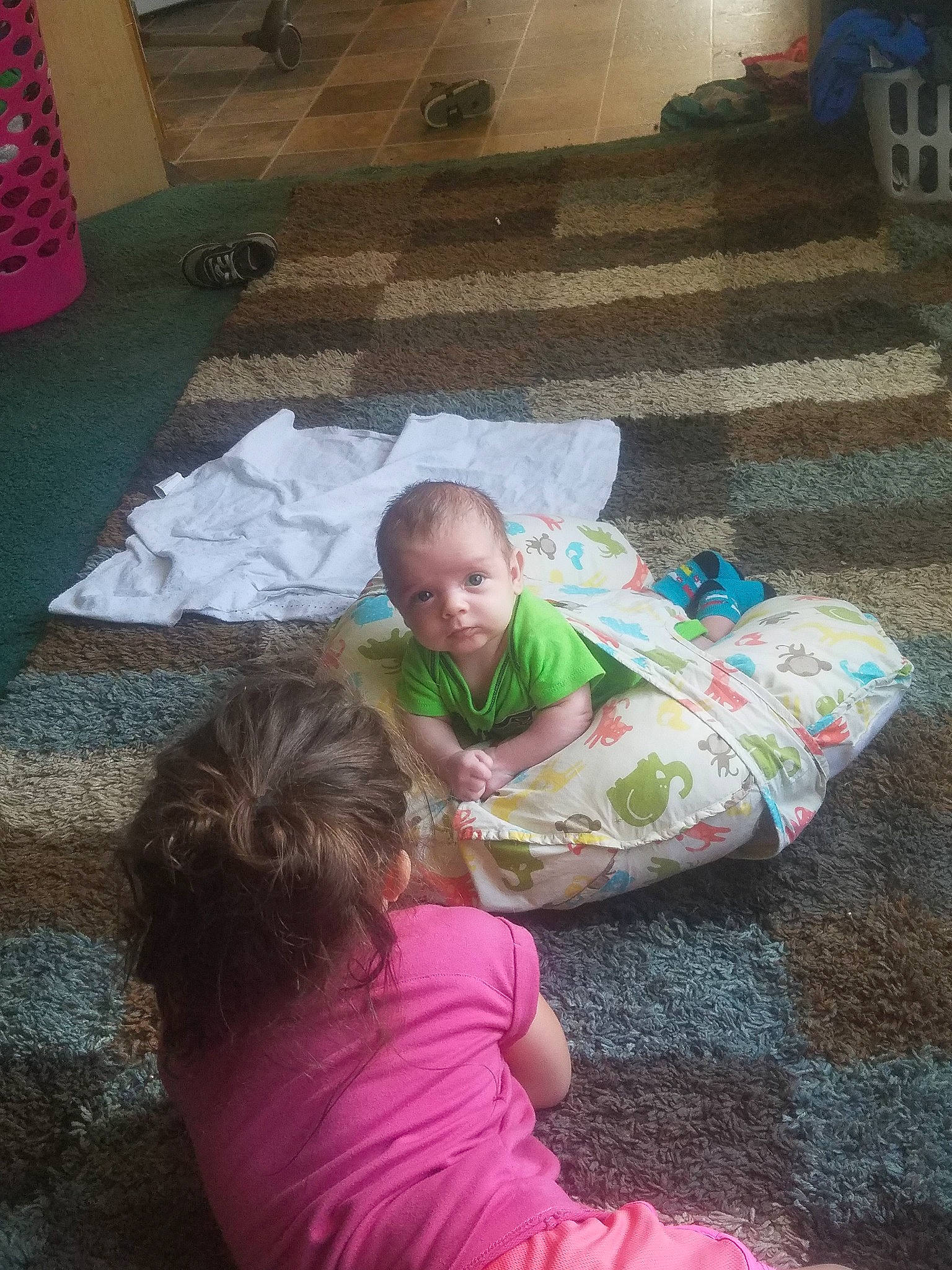 Brock is registered to the contest to win money with this photo: baby, carpet, child, comfort, floor, flooring, fun, grass, lap, leisure, magenta, person, pink, play, road_surface, room, sidewalk, sitting, t_shirt, toddler