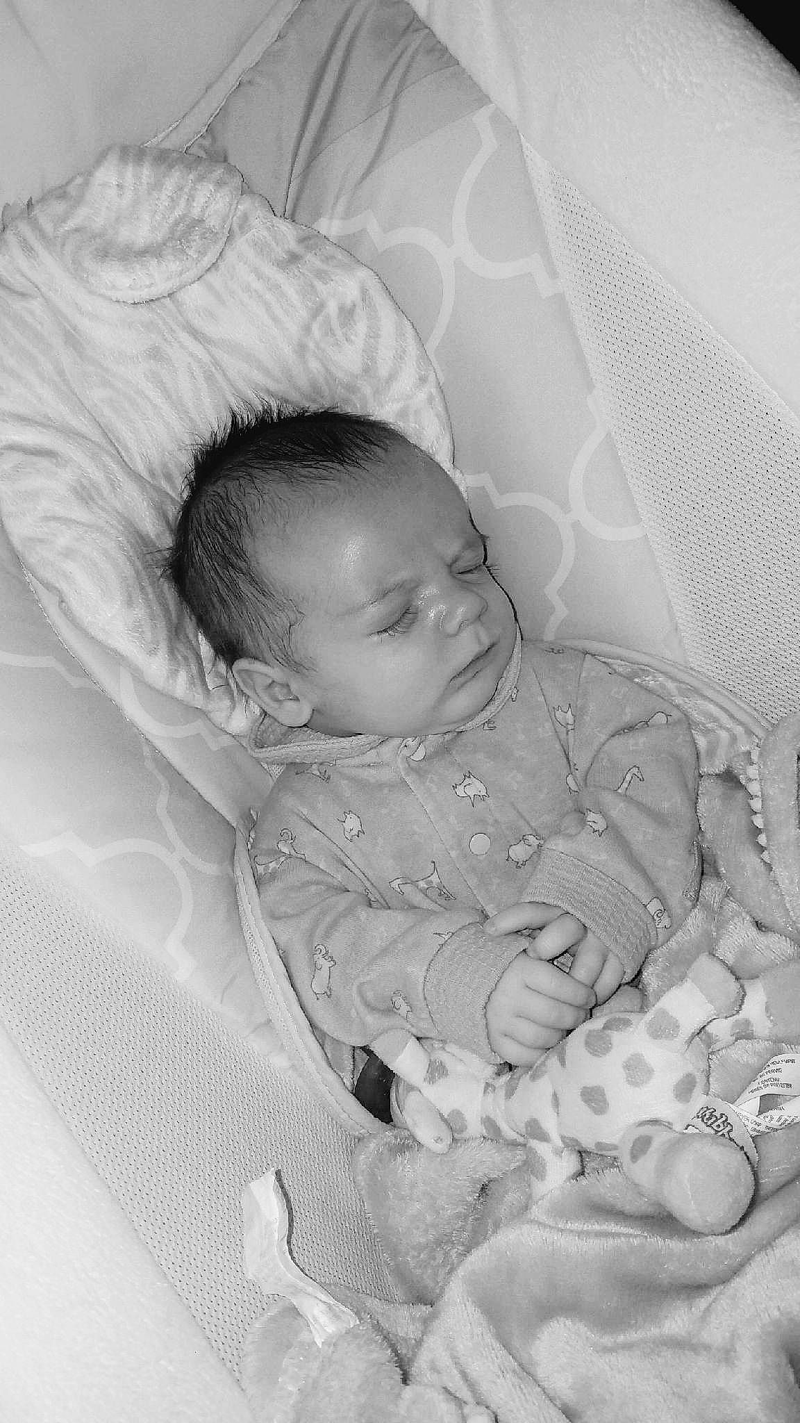 Brock is registered to the contest to win money with this photo: baby, baby_sleeping, baby_toddler_clothing, black_and_white, cheek, child, comfort, eye, hairstyle, hand, head, human_body, infant_bed, iris, lip, mouth, person, product, skin, textile