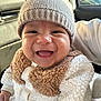 baby, smiling, hat, knit_hat, infant, cute, fluffy_clothing, white_clothing, beige, car_seat, child, happy, portrait, closeup, person, warm_clothing, indoor, face, young_child, cozy