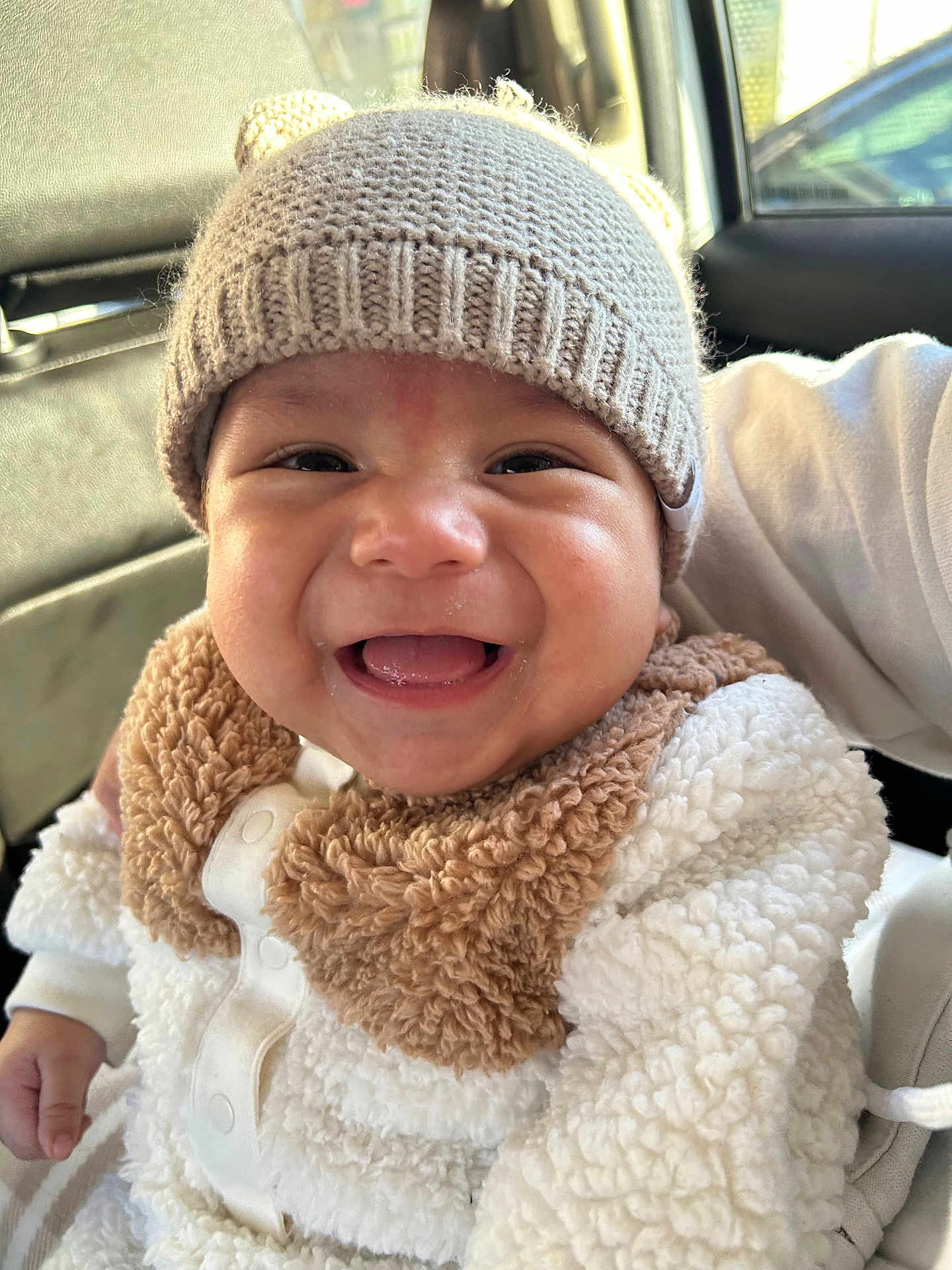 Isael David Huerta joined the competition — help win amazing prizes! baby, smiling, hat, knit_hat, infant, cute, fluffy_clothing, white_clothing, beige, car_seat, child, happy, portrait, closeup, person, warm_clothing, indoor, face, young_child, cozy