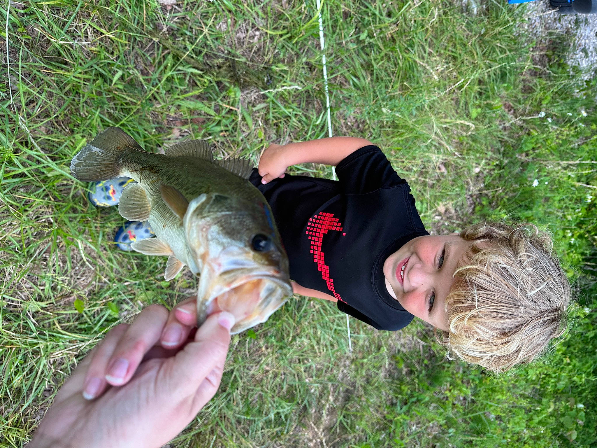 Grayson is registered to the contest to win money with this photo: elbow, fun, grass, grassland, groundcover, hand, happy, hat, joy, leisure, people_in_nature, person, plant, smile, soil, t_shirt, thumb, tree, wrist