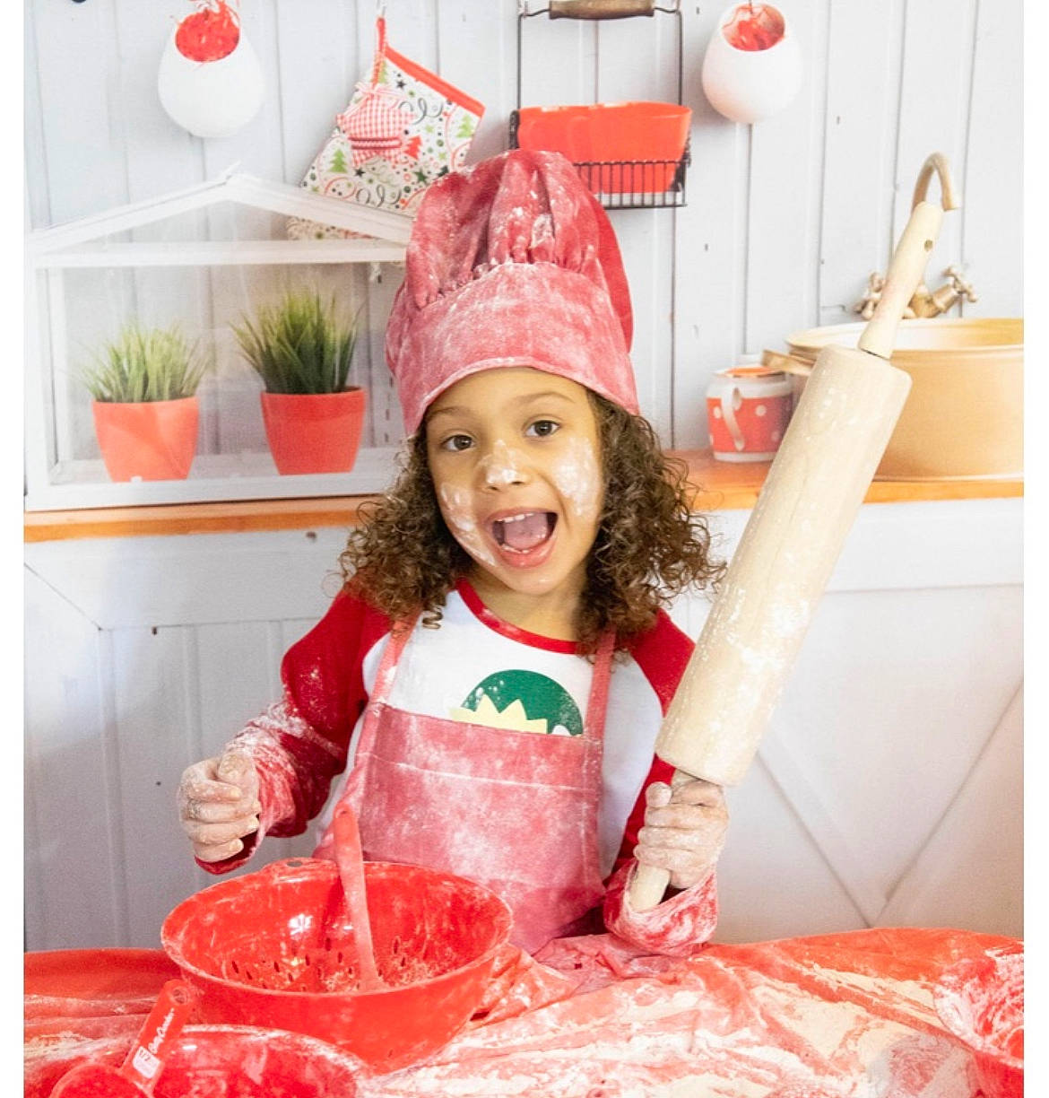 Nylah is registered to the contest to win money with this photo: cap, cooking, costume_hat, fashion_accessory, happy, hat, headwear, holiday, kitchen, magenta, orange, party_supply, pattern, peach, person, pink, plant, red, room, smile