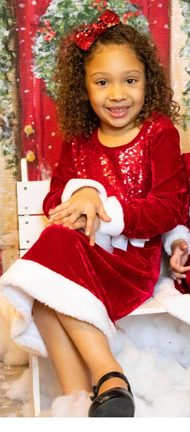 Nylah joined the competition — help win amazing prizes! baby_toddler_clothing, chair, cheek, child, event, facial_expression, fur, happy, human_body, human_leg, joy, knee, lap, pattern, person, red, sitting, sleeve, smile, thigh