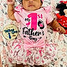 baby, infant, child, pink_outfit, headband, plush_toy, minnie_mouse, floral_blanket, celebration, first_fathers_day, wooden_plaque, smiling, cute, tutu_skirt, lying_down, indoors, adorable, portrait, clothing, happy