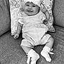 baby, black_and_white, child, clothing, comfort, couch, cushion, cute, fabric, floral_pattern, happy, headband, indoors, infant, portrait, seated, small_person, smiling, socks, texture