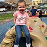 Rae Bates is registered to the contest to win money with this photo: blue_sky, buildings, cars, chalk, child, climbing_structure, clouds, daylight, fence, friends, fun, girl, grass, jeans, outdoor, pink_shirt, play, playground, smile, white_sneakers