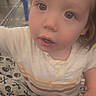 toddler, child, shopping_cart, blanket, skull_pattern, curious, indoor, face, clothing, white_shirt, pants, hand, portrait, store, aisle, closeup, expression, young_child, baby, retail