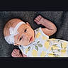 Olive is registered to the contest to win money with this photo: baby, infant, child, portrait, lying_down, smiling, face, eyes, bow, headband, onesie, yellow, lemon_pattern, clothing, gray_blanket, indoor, cute, happy, baby_photography, close_up