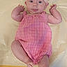 baby, child, infant, pink, romper, dress, headband, bow, plaid, lying_down, portrait, smiling, happy, indoors, changing_mat, baby_fashion, arms_raised, barefoot, face, photography