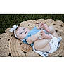 Charlotte is registered to the contest to win money with this photo: baby, headband, blue_clothing, grass, woven_mat, outdoor, infant, diaper, cute, playful, child, smiling, feet, hands, lying_down, head, skin, person, nature, summer