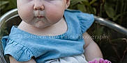 Charlotte joined the competition — help win amazing prizes! baby, child, blue_eyes, curly_hair, headband, flower, outdoor, greenery, dress, blue_clothing, white_clothing, sitting, clear_bowl, cute, portrait, nature, puckered_lips, skin, hand, infant