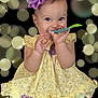 baby, background, bokeh, child, colorful_object, cute, dress, face, feet, glowing, hand, happy, headband, infant, playful, portrait, purple_flower, sitting, smiling, yellow_dress