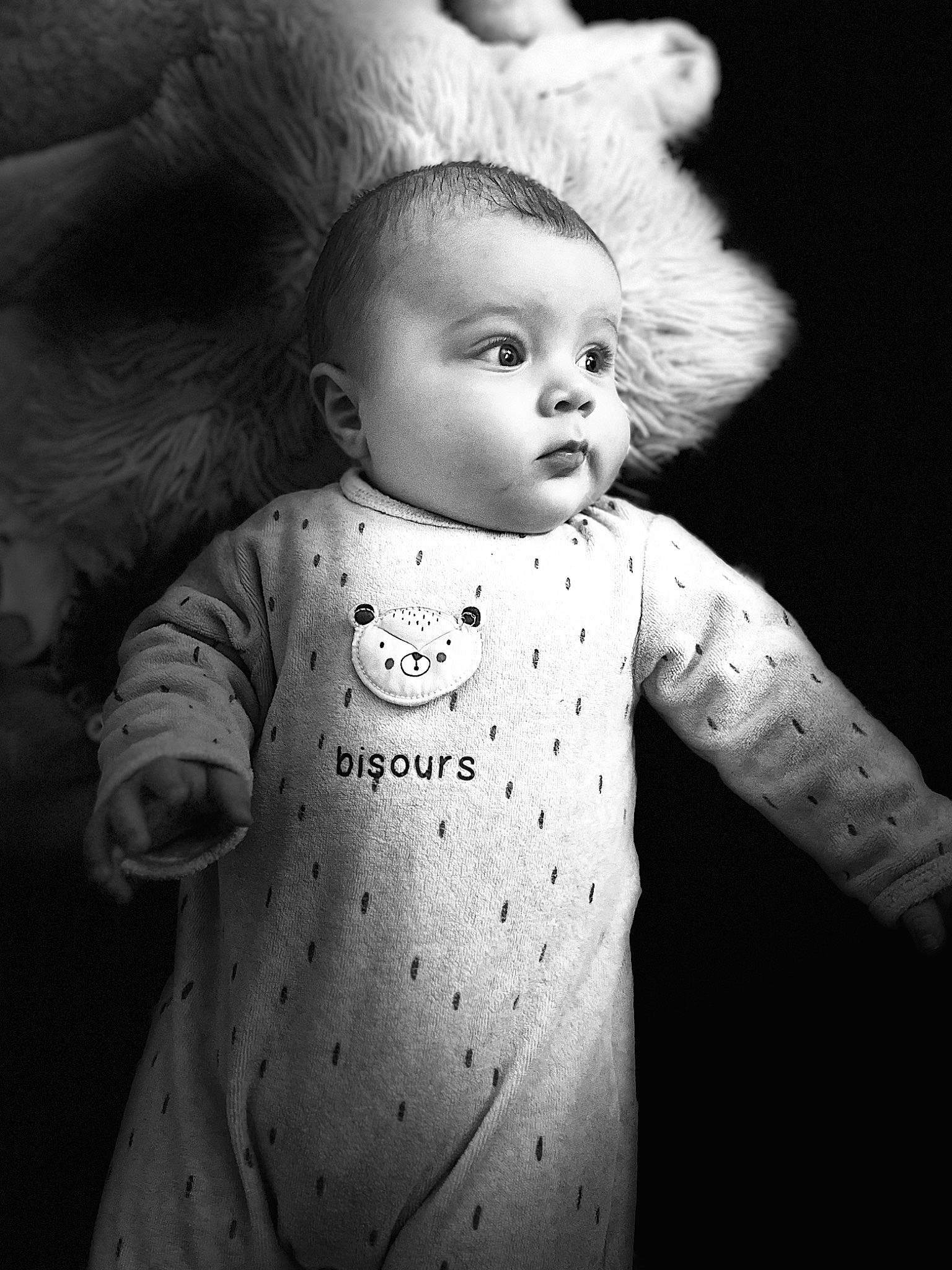 Leyan participe au concours pour gagner de l'argent avec cette photo : baby, baby_toddler_clothing, black_and_white, cheek, eye, face, flash_photography, grey, happy, head, human_body, monochrome, monochrome_photography, one_piece_garment, organ, person, skin, sleeve, standing, style