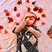 Zen joined the competition — help win amazing prizes! baby, infant, flower, pink, blanket, heart_shape, cute, lying_down, patterned_clothing, soft_texture, petals, adorable, portrait, child, happy, playful, small_hands, colorful, decorative, resting