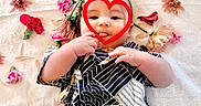 Zen is registered to the contest to win money with this photo: adorable, baby, blanket, child, cute, decorative, face, flowers, hand, heart_shape, infant, lying_down, patterned_clothing, peaceful, pink_flowers, playful, portrait, red_flowers, soft_texture, tongue_out