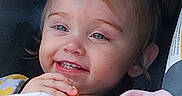 Julie joined the competition — help win amazing prizes! toddler, child, smiling, pigtails, blanket, snack, blue_eyes, happy, cute, portrait, face, indoors, baby, cozy, clothing, person, young_child, closeup, seated, comfort