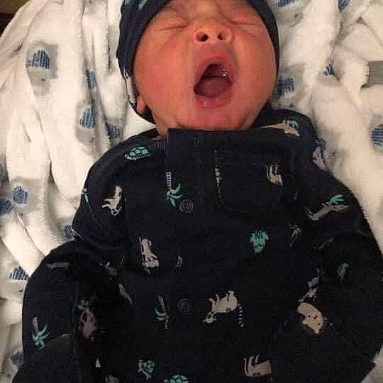 Zamar is registered to the contest to win money with this photo: baby, baby_toddler_clothing, button, camouflage, cheek, hood, person, sleeve, tongue