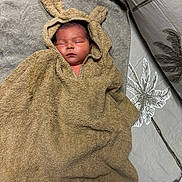 Clint a rejoint le concours — aidez-le/la à gagner de superbes lots ! baby, sleeping, towel, hooded_towel, bunny_ears, bed, blanket, soft_texture, infant, cute, peaceful, indoors, resting, child, portrait, cozy, fabric, comfort, warm, person