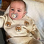 baby, pacifier, knitwear, fox_pattern, cream_color, indoor, couch, blanket, face, child, comfort, cute, relaxing, portrait, infant, sweater, pants, home, pacifier_clip, soft_lighting