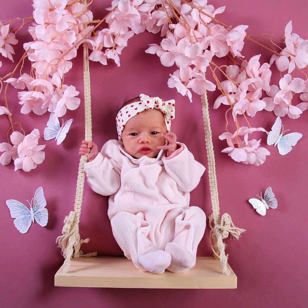 Emy participe au concours pour gagner de l'argent avec cette photo : baby, infant, swing, pink, flower, butterfly, headband, cute, soft_clothing, wood, rope, background, decoration, portrait, child, indoor, adorable, spring, playful, smiling