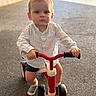 Henri a rejoint le concours — aidez-le/la à gagner de superbes lots ! toddler, child, tricycle, red, outdoor, asphalt, serious_expression, shorts, striped_shirt, socks, hands, face, vehicle, toy, wheels, handlebars, young_child, portrait, baby, person